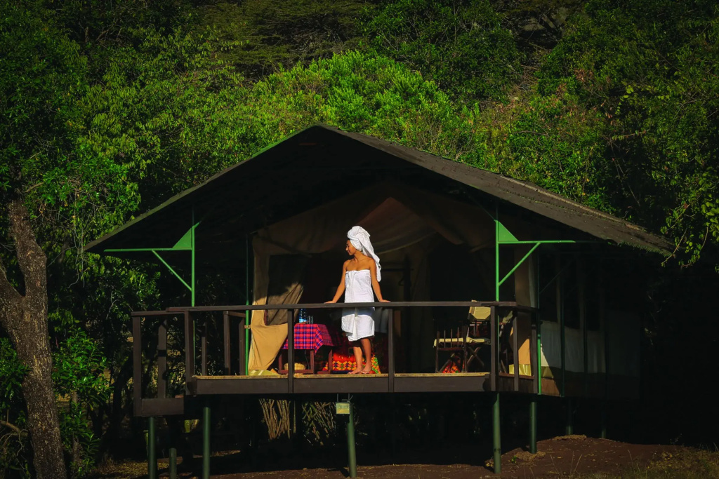 Guest on the veranda of a tent set into the forest