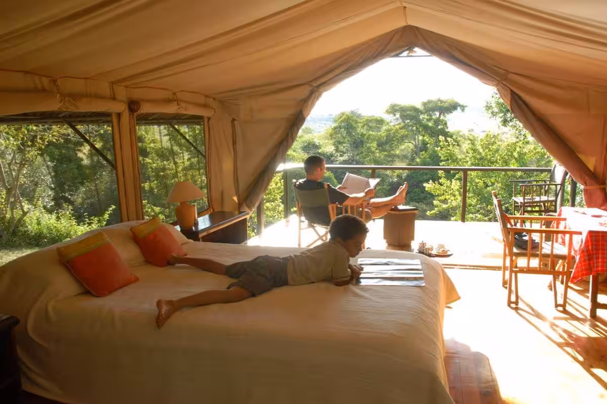 Family tent interior with king bed and forest view